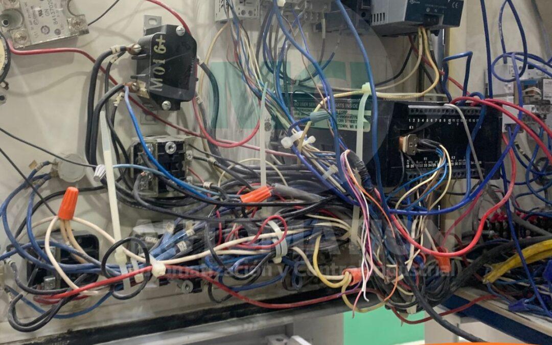 Técnico realizando inspección y reapriete de conexiones en un tablero eléctrico industrial.