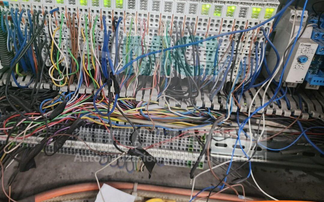 Técnico revisando modificaciones eléctricas realizadas en una máquina industrial durante una inspección de mantenimiento.