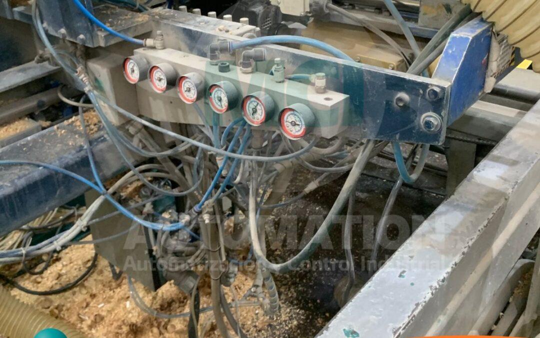 Técnico inspeccionando conexiones neumáticas en una instalación industrial para detectar fugas de aire comprimido.
